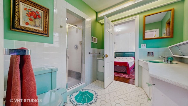 bathroom with vanity, walk in shower, and tile walls