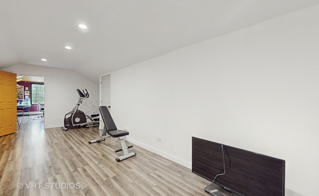 exercise room featuring light hardwood / wood-style flooring and vaulted ceiling