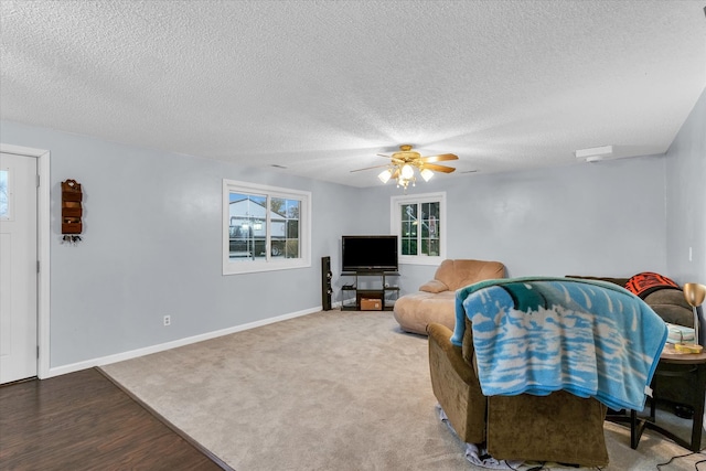 living room featuring hardwood / wood-style floors, a textured ceiling, and ceiling fan