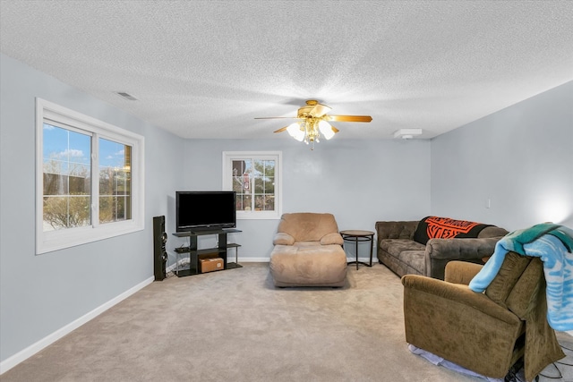 living room with a textured ceiling, carpet floors, and ceiling fan