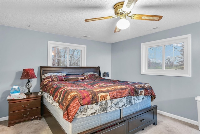 carpeted bedroom with ceiling fan and a textured ceiling