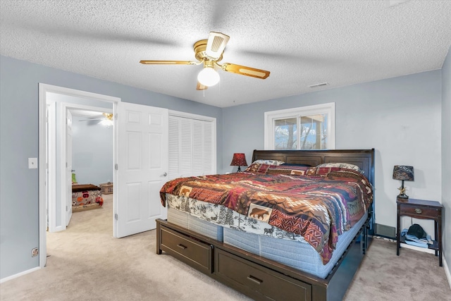 bedroom featuring ceiling fan, light colored carpet, and a textured ceiling