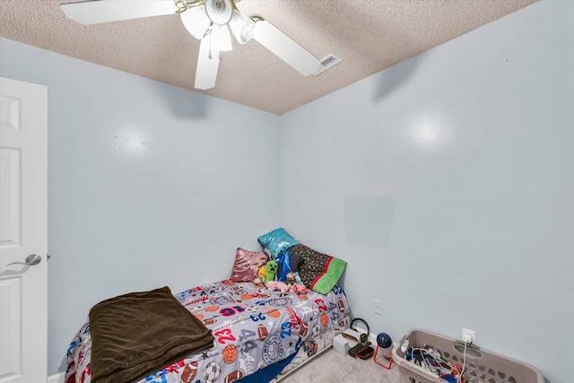 carpeted bedroom featuring ceiling fan and a textured ceiling