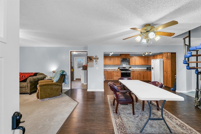 dining room featuring ceiling fan, dark wood-type flooring, and a textured ceiling