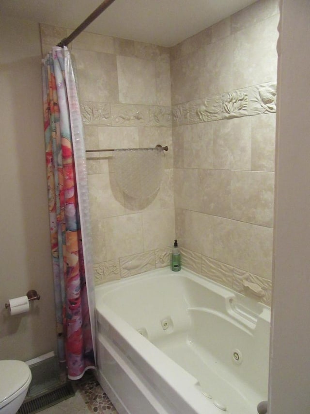 bathroom with tile patterned floors, shower / bath combination with curtain, and toilet