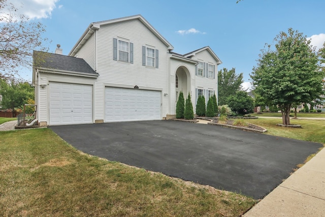 view of front of property featuring a front yard and a garage