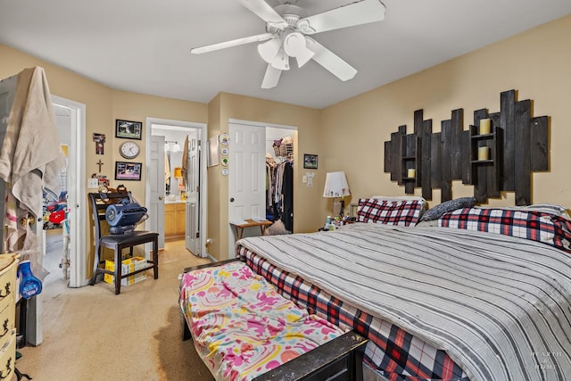 carpeted bedroom with a walk in closet, ensuite bath, a closet, and ceiling fan