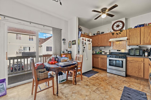 kitchen with ceiling fan, white fridge with ice dispenser, and gas range