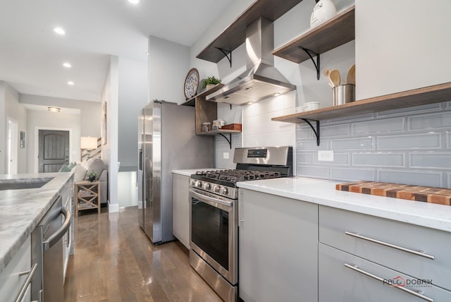 kitchen with dark hardwood / wood-style flooring, backsplash, wall chimney exhaust hood, stainless steel appliances, and sink