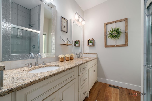 bathroom featuring hardwood / wood-style floors, vanity, and a shower with shower door