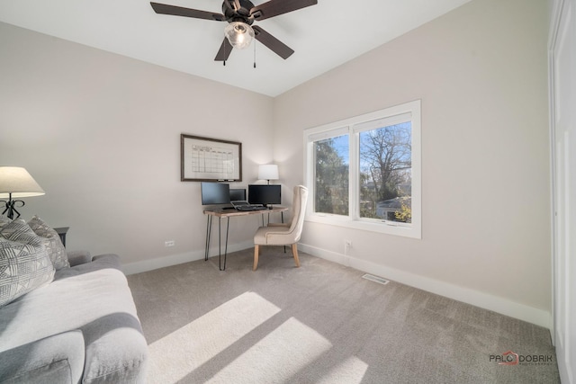 carpeted office space featuring ceiling fan