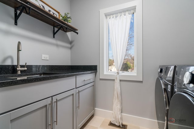 laundry area featuring cabinets, light tile patterned floors, separate washer and dryer, and sink