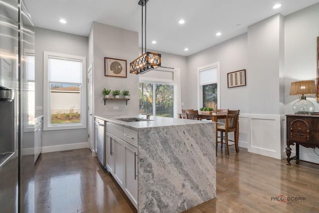 kitchen with dark hardwood / wood-style flooring, a wealth of natural light, sink, and pendant lighting