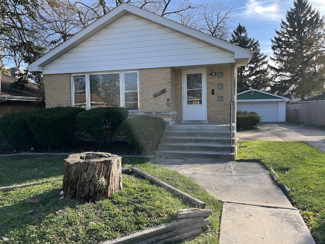 bungalow-style home with an outbuilding, a front lawn, and a garage