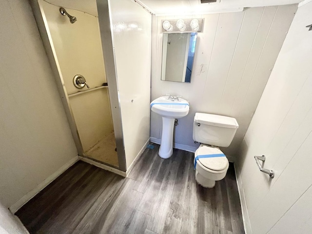 bathroom with walk in shower, toilet, and hardwood / wood-style flooring