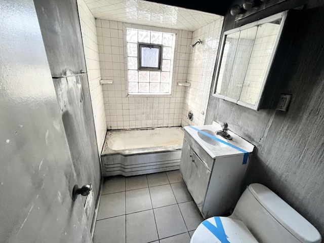 full bathroom with tile patterned flooring, vanity, tiled shower / bath combo, and toilet