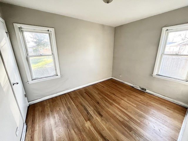 unfurnished room featuring hardwood / wood-style flooring and plenty of natural light