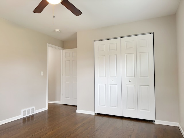 unfurnished bedroom with ceiling fan, a closet, and dark wood-type flooring