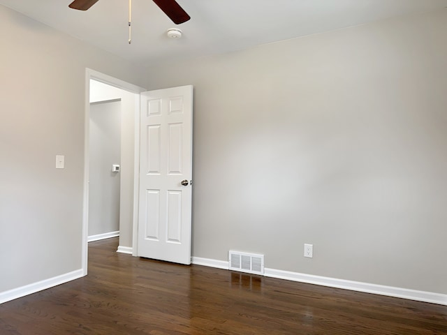 empty room featuring ceiling fan and dark wood-type flooring