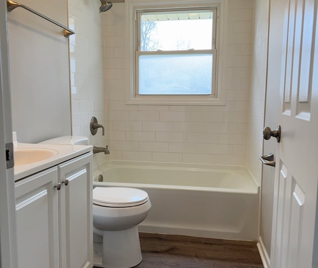 full bathroom with vanity, toilet, wood-type flooring, and tiled shower / bath combo