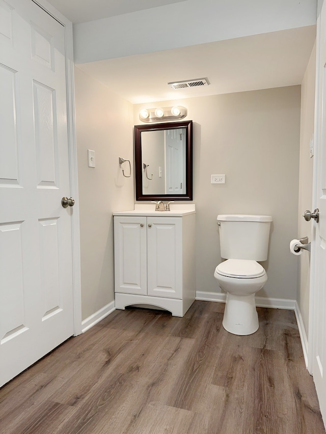 bathroom featuring hardwood / wood-style floors, vanity, and toilet