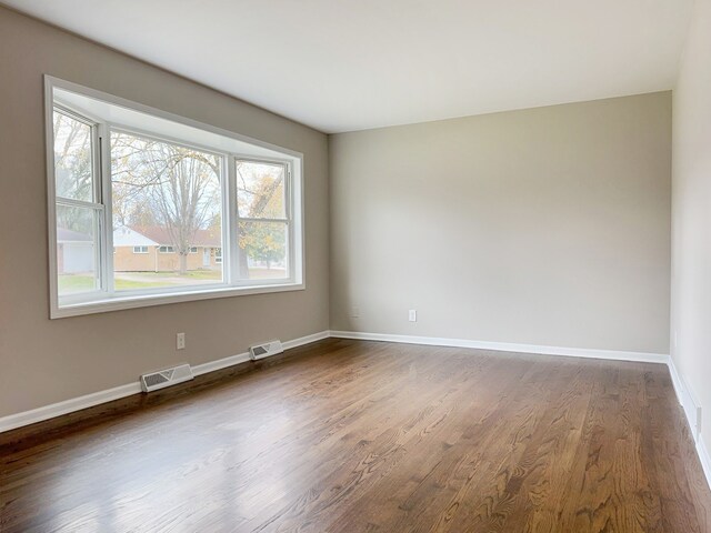 unfurnished room featuring dark hardwood / wood-style flooring