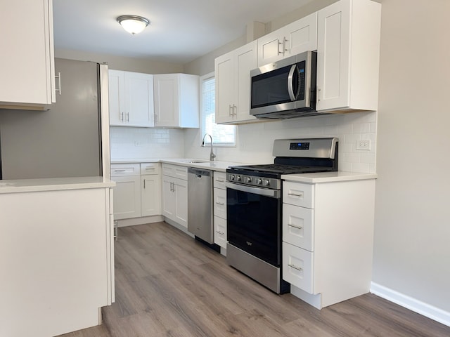 kitchen featuring white cabinetry, light hardwood / wood-style flooring, sink, and appliances with stainless steel finishes