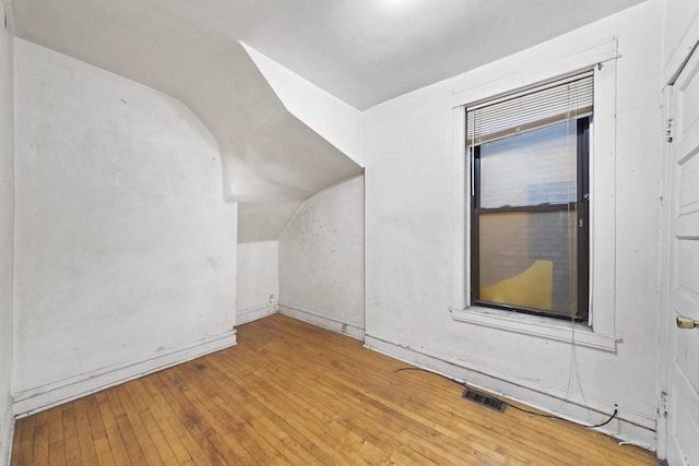 bonus room featuring light wood-type flooring and vaulted ceiling