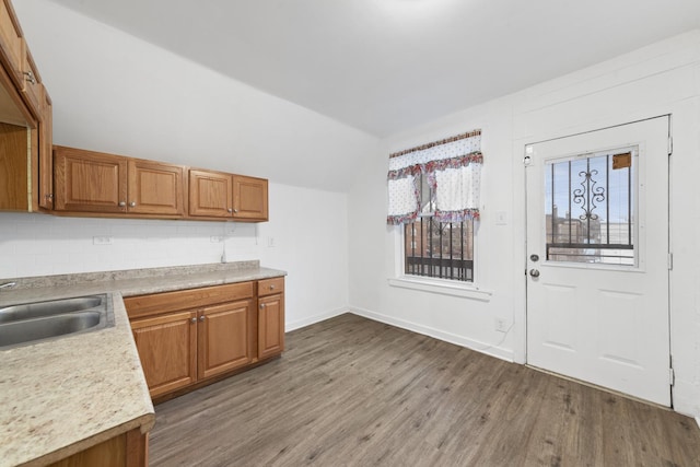 kitchen with decorative backsplash, light hardwood / wood-style floors, and sink