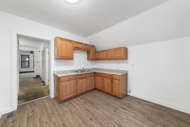 kitchen with decorative backsplash, ceiling fan, sink, wood-type flooring, and lofted ceiling