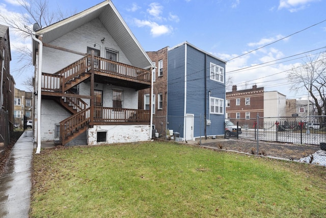 back of property featuring a deck and a lawn