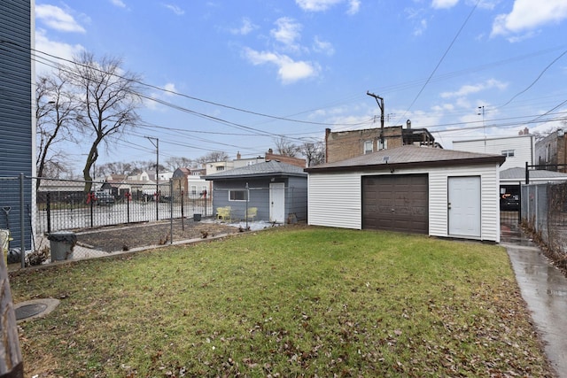 rear view of property featuring an outbuilding, a garage, and a lawn