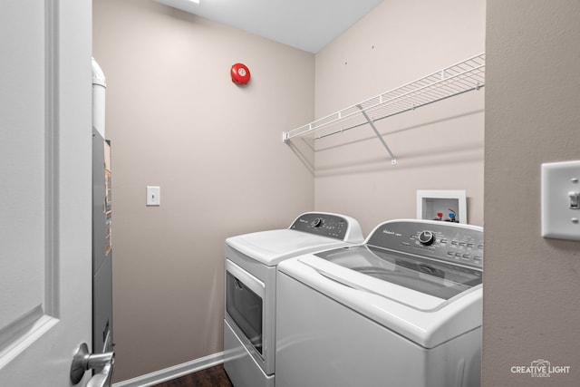 laundry area featuring washing machine and dryer and dark wood-type flooring