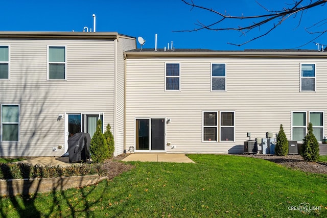 back of property with a yard, cooling unit, and a patio area