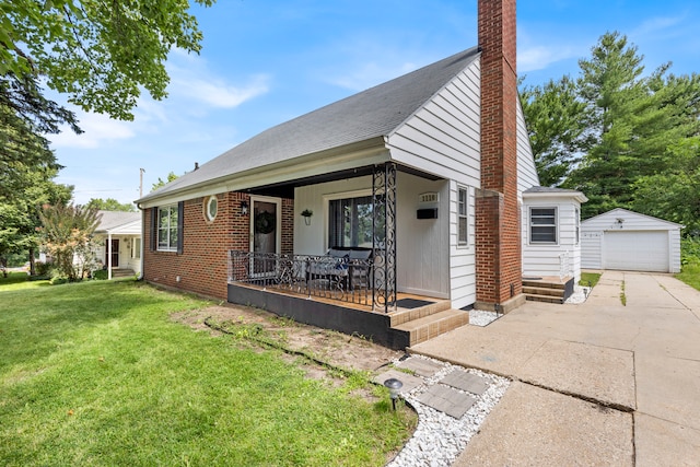 bungalow featuring a garage, covered porch, an outdoor structure, and a front lawn