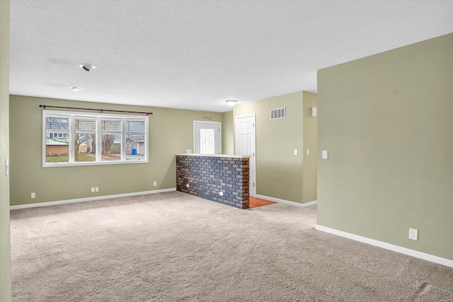 carpeted empty room featuring a textured ceiling