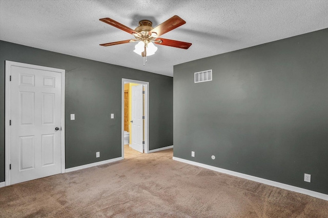 carpeted spare room with ceiling fan and a textured ceiling