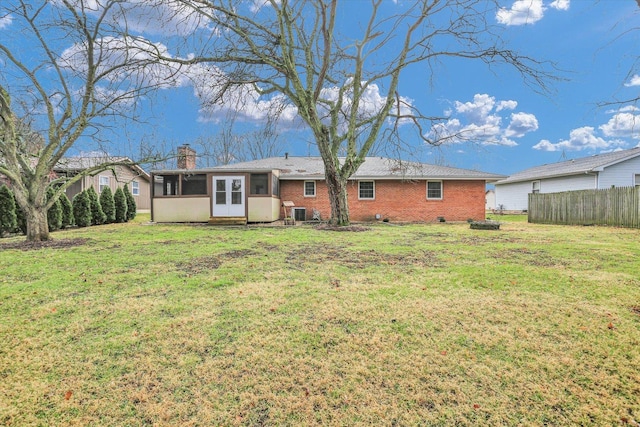 rear view of property with a yard and a sunroom