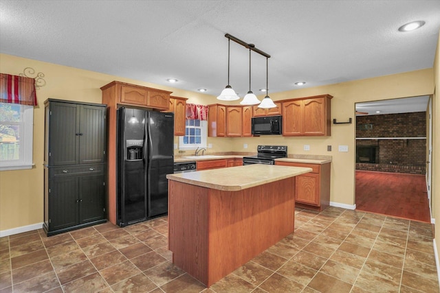 kitchen featuring sink, hanging light fixtures, a textured ceiling, a kitchen island, and black appliances