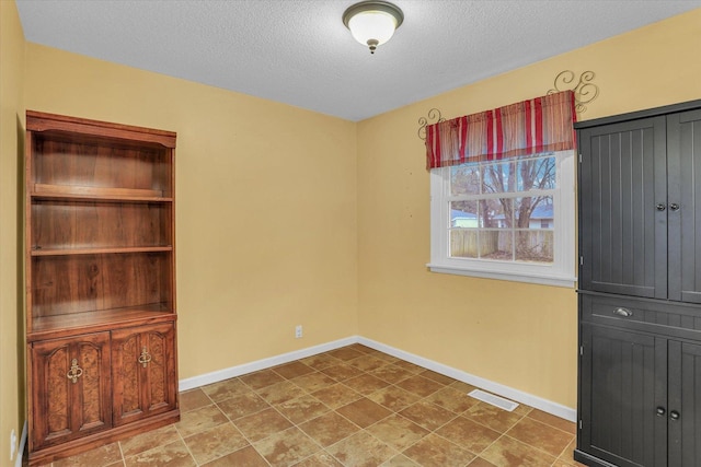 unfurnished room with a textured ceiling