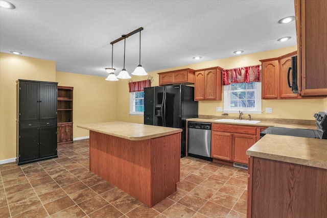 kitchen featuring sink, a healthy amount of sunlight, decorative light fixtures, a kitchen island, and black appliances