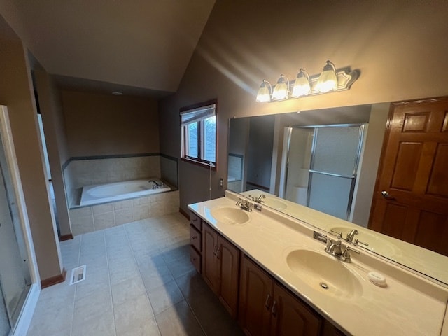 bathroom with tile patterned flooring, vanity, independent shower and bath, and vaulted ceiling