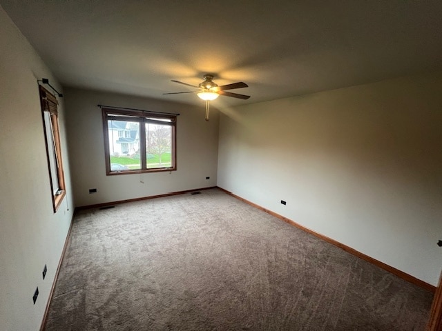 spare room with carpet flooring, a barn door, and ceiling fan