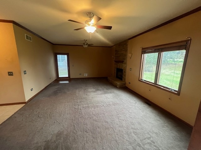 carpeted empty room featuring a fireplace, ceiling fan, and ornamental molding