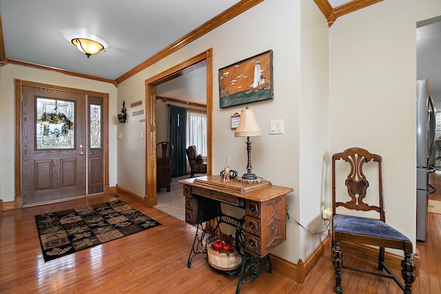 foyer entrance with ornamental molding, a healthy amount of sunlight, and wood-type flooring