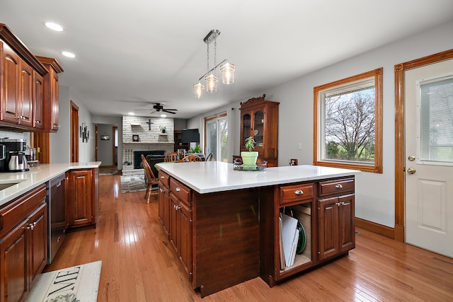 kitchen featuring decorative light fixtures, plenty of natural light, and light hardwood / wood-style flooring