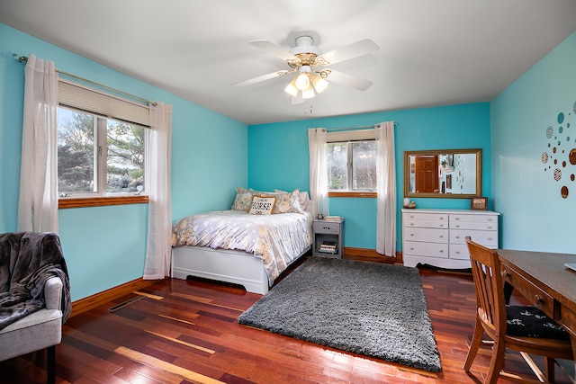 bedroom featuring ceiling fan, dark wood-type flooring, and multiple windows