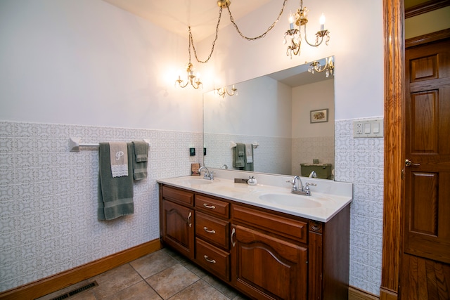 bathroom featuring vanity, an inviting chandelier, tile patterned floors, and tile walls