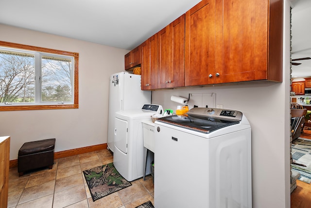 clothes washing area with cabinets, ceiling fan, and washer and dryer