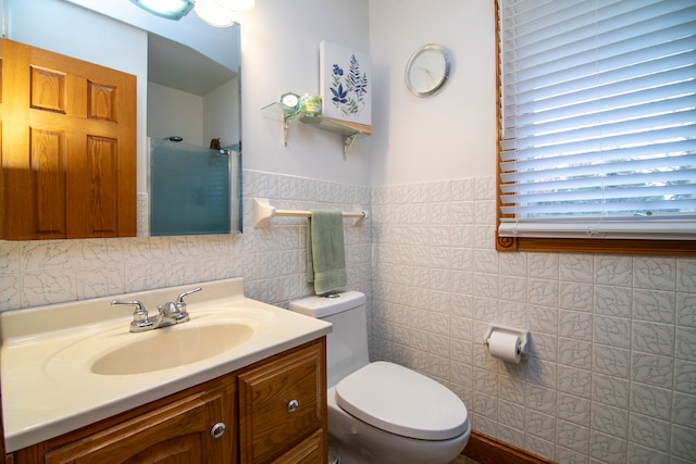 bathroom featuring vanity, tile walls, and toilet